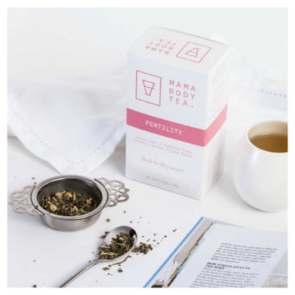 An elegant white dish and mug containing fertility tea from Mama Body Tea, showcasing the nourishing blend of herbs inside that are preconception helping balance hormones.  tea includes, Organic Raspberry Dong, Quai Root, Shativari Root, Tulsi, Skullcap